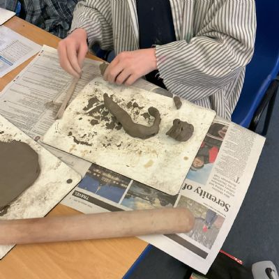 Children making clay lizards